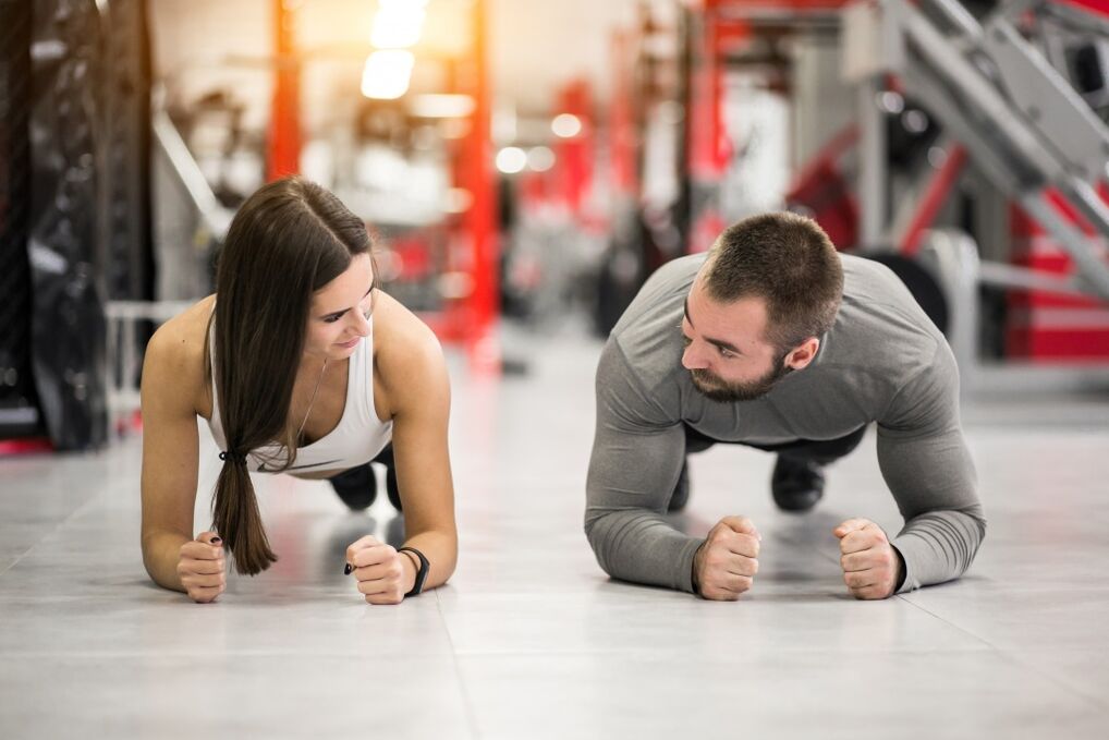Мъж и жена изпълняват упражнението Планк, предназначено за всички мускулни групи